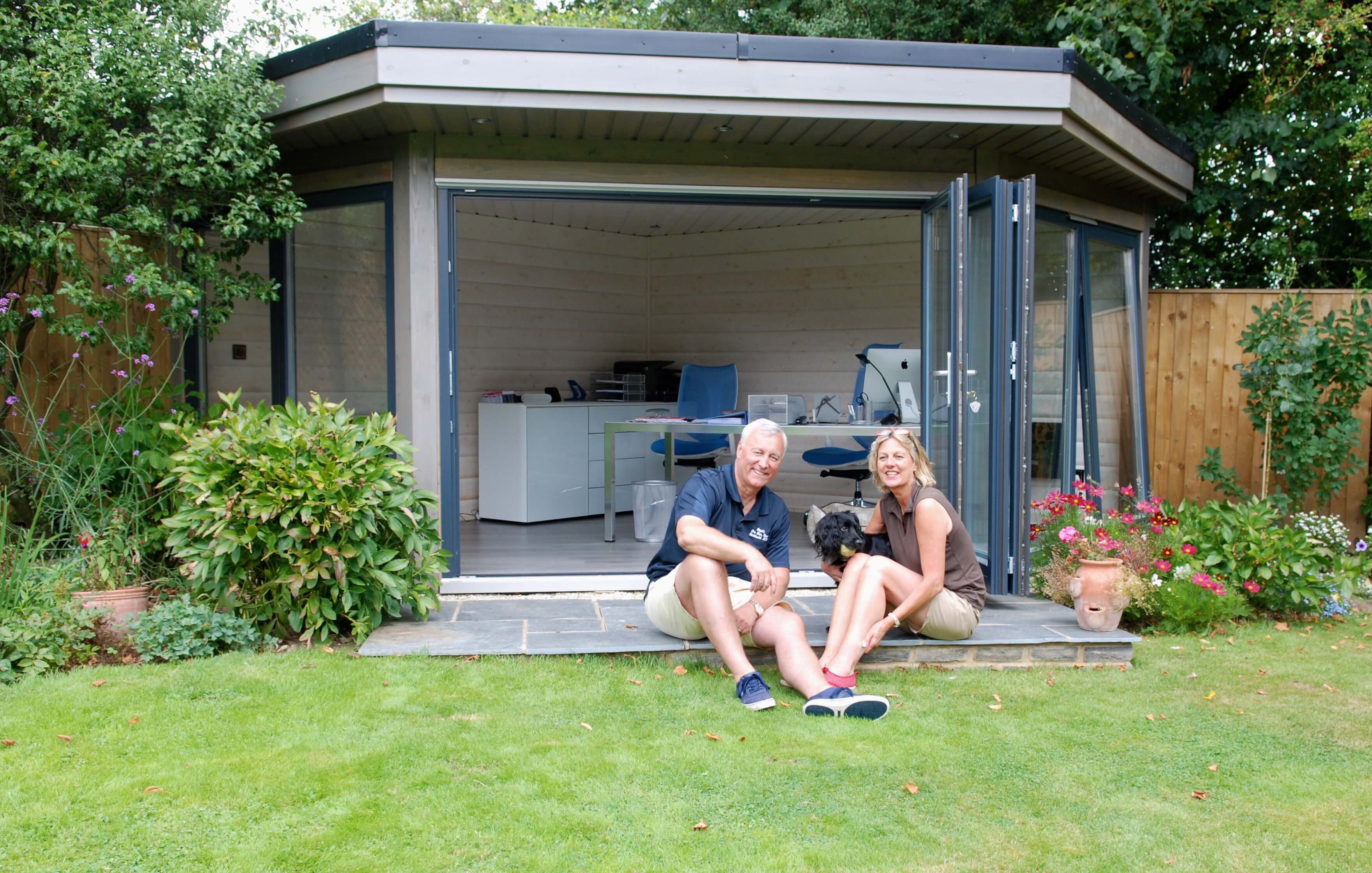 The Boyds relaxing next to their solid log garden office The Boyds relaxing next to their solid log garden office