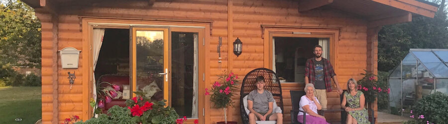 Grandmother and family sat in front of garden annex