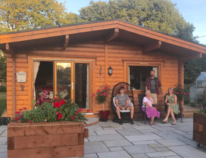 Grandmother and family sat in front of garden annex